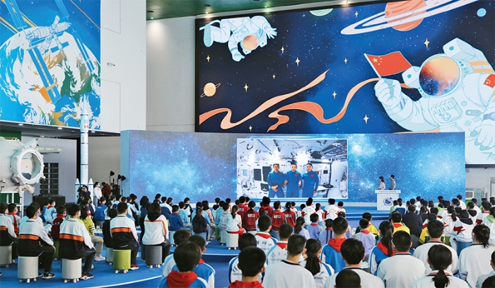 2021年12月9日，“天宫课堂”第一课开讲，神舟十三号乘组航天员翟志刚、王亚平、叶光富在中国空间站进行太空授课。图为学生们在中国科学技术馆听课。 新华社记者 金立旺摄